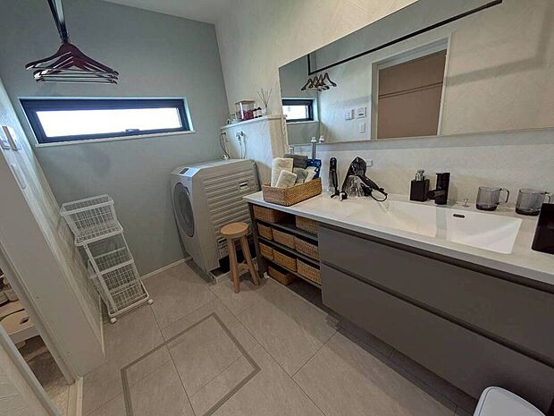 【洗面台・洗面所】広々とした洗面台に長い鏡を設け、清潔感と使いやすさを両立。忙しい朝の時間もスムーズに過ごせます。