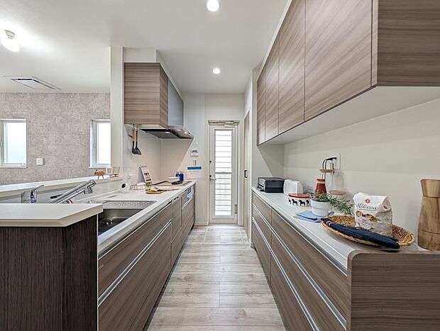 【2号地キッチン】家族とのつながりを大切にした対面式キッチンは、料理をしながら会話を楽しめる家族の温かさを感じる空間です。豊富な収納と使いやすい設備が整い、使いやすさとデザイン性を兼ね備えています。