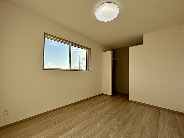 【【1号棟 洋室(2)】】日差しが心地よく入る洋室。奥のクローゼットは上部が開いた設計で、圧迫感が少なく空間を広く感じられます。