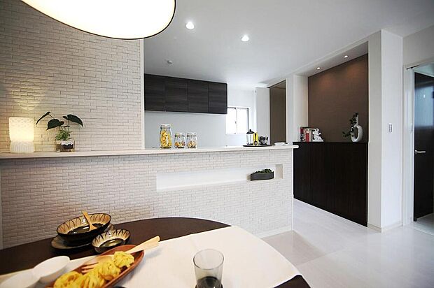 【【当社施工例】リビング】ブラウンのアクセントクロスと間接照明がお洒落な収納棚が備わっています。棚上には、お好みのインテリアやご家族の思い出の品などを飾ることができます。