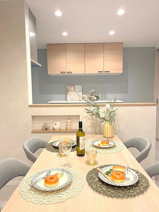 【【当社施工例】ダイニング】対面式キッチンですので、リビング側から配膳や後片付けの補助ができ、効率的です。コンロ回りは壁が設けられていますので、リビング側へ油はねしにくい仕様です。