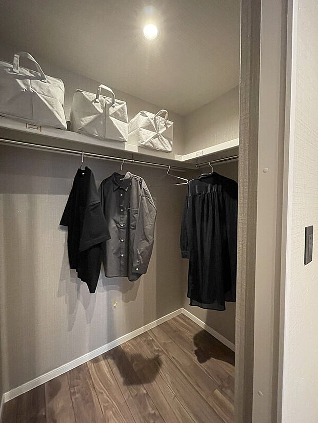 【 【当社施工例】収納】L字型のウォークインクローゼットが備わっています。ハンガーパイプ付きで、ご家族皆様の衣類や小物類をすっきり収められます。上部の枕棚には、普段使用しない季節ものを収納できます。