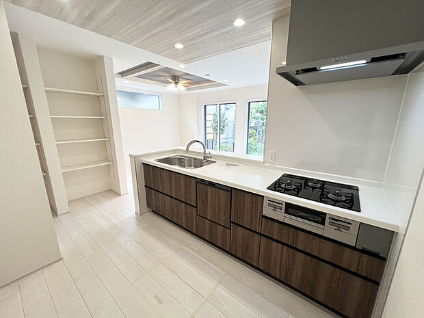 【【2号棟】キッチン】食器洗乾燥機＋浄水器を搭載したシステムキッチン。コンロ横には小窓があるため、お料理中もスムーズに換気ができます。飲料やお米などの重たいものの保管に便利な、床下収納付き◎