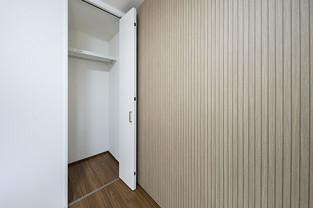 【【洋室(約4.5帖】】木目調のアクセントクロスが映えるモダンな洋室。高さのあるクローゼットには枕棚とハンガーパイプを備え、衣類から小物まで効率よく収納できます。