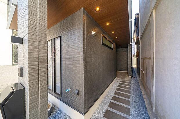 【【本分譲地に建築可能な建物プラン例】】玄関へと続くアプローチは夜が特に印象的。木目調の天井とダウンライトも相まり、リッチさを感じさせます。《分譲地外:建物面積104.89m2、建物価格2181万円》