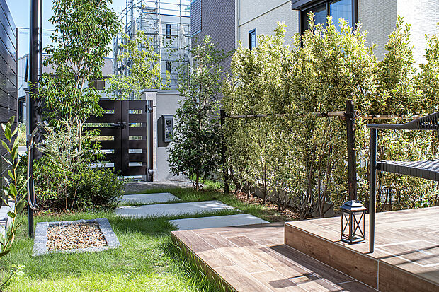 【アプローチ】木調門扉、混合水栓のあるゆとりあるアプローチ空間。木調タイルテラスにベンチを置いて、ペットと一緒にゆったり過ごしたり、マウンテンバイクのメンテナンス空間として活用できる広さを確保しました。