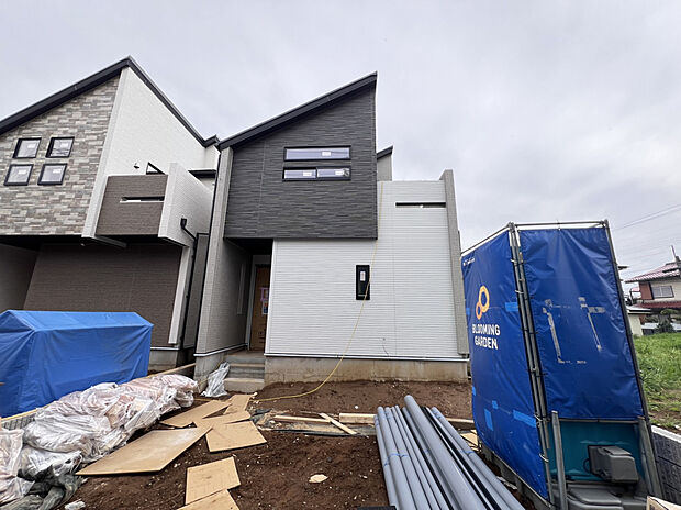 【【1号棟外観】】白×黒×グレーのスタイリッシュな外観です。外観に調和するデザインの機能門柱を設置。TVモニター付きインターホンを備えており、事前に来訪者を確認してから応対ができます。