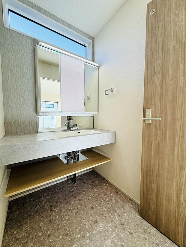 【【洗面台:1号棟】】洗面台が広い、フルフラットカウンター。三面鏡の内側は収納スペースに。洗面台は傷つきにくく、汚れがつきにくい素材を使用しており、お手入れもカンタンです。