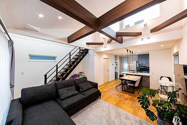 【内観 施工事例】勾配天井とスケルトン階段が開放感により拍車をかける心地よい寛ぎの家。大きな高窓からは暖かい日差しが届く。化粧梁とスポットライトが瀟洒（建物プラン例 建物価格／2300万円 建物面積／97.50m2）