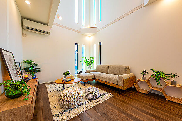 【【 住協建設の施工例 】】天井高を活かしたダイナミックな吹き抜け空間。スリット窓から光が降り注ぐ、開放感に満ちたリビング。