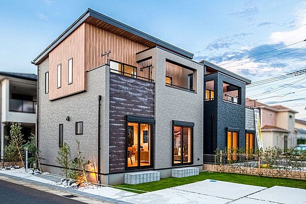 【【 住協建設の施工例 】】異素材が織りなす洗練のファサード。 温もりのある木目パネルとグレーのコントラスト。開放的なテラスが暮らしに彩りを添えるデザイン住宅。