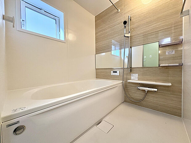 【【2号棟/浴室】】木目調のアクセントパネルを採用した、温かみのある雰囲気の浴室です。浴室換気乾燥機のほか、ワイドミラーやシャワー用スライドバーなど、機能的な設備を搭載しています。