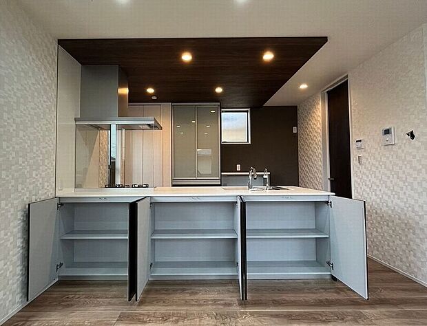 【キッチン】リビング側に便利な収納完備!普段使いのお薬やお子様のおもちゃをすぐ取り出せて便利!キッチン上部は折下天井を採用、高級感あふれるデザイン、お洒落で機能的な空間を実現します!