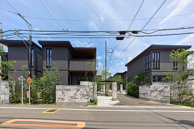 【まちなみ2（撮影_2024年5月）】斜めに設計された大理石調のオブジェは、「八の字」に手を広げるイメージで分譲地に訪れる人々を迎え入れます。※販売済区画を含む場合がございます。最新の販売状況は区画図等をご参照下さい。