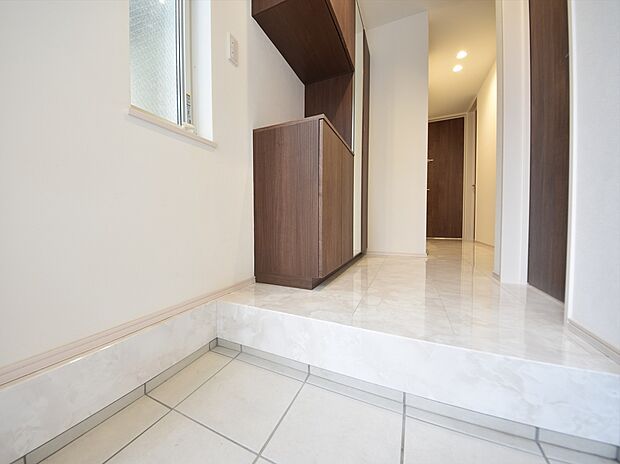 施工例　扉を開けた瞬間、目の前に広がる大理石調のフローリングがエントランスに一層の輝きと開放感を演出