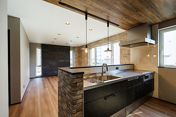 【1号棟／キッチン】
キッチンは木目調の下がり天井。食洗機やお手入れのしやすいIH、便利なタッチレス水栓を備え、見た目も機能も充実の心地よい空間に。
（2025年5月撮影）