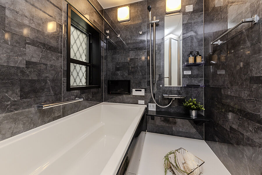 【浴室】
浴室はモノトーンの石貼デザインパネルを採用。床は足裏がひんやりしない「温（ぬ）クリンフロア」。洗面室には、着替えやタオル類を収納できるリネン庫を設けています。