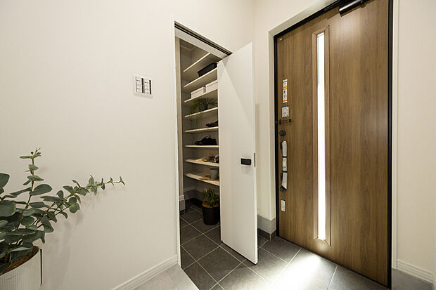 【玄関(2号地)】玄関ドアは光と通すスリット入り。玄関からLDKへの直通動線とは別に、SCLや洗面室を通り抜けてアプローチも可能。帰宅時の手洗いや着替えがスムーズで、来客時の動線と分ける事ができます。