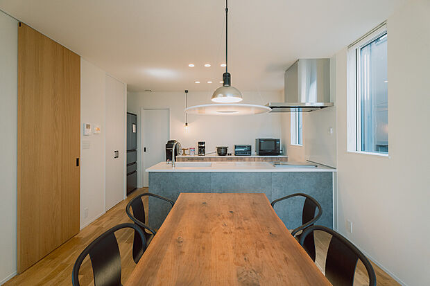 【家族の会話が弾むダイニングキッチン】温かみのある木のテーブルと、スタイリッシュなキッチンが調和。食事も会話も楽しめる心地よい空間です。