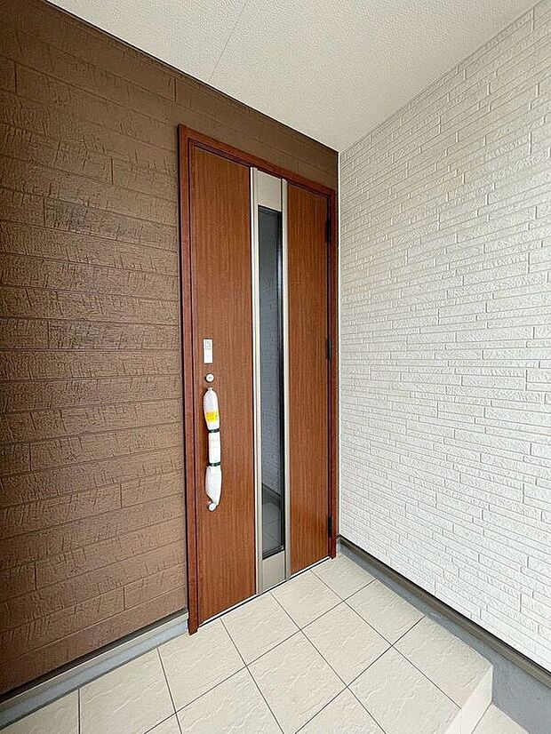 【玄関】屋根のある玄関アプローチで、雨の日も濡れずにスムーズに出入りできます。傘を折りたたむ際や荷物の多い日、お子様のレインコートの脱ぎ着も落ち着いて行える、暮らしの快適さを高める配慮が嬉しい設計です。