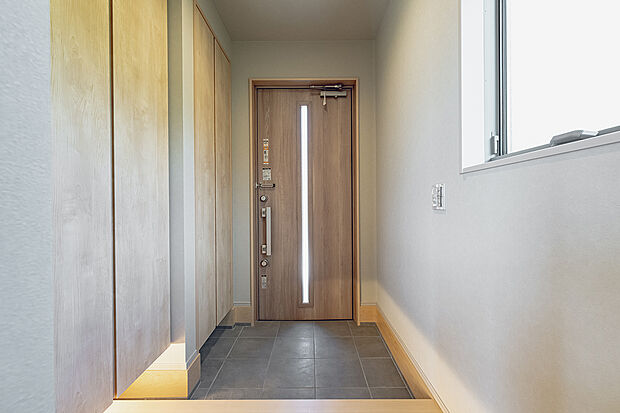 【玄関(L-8号棟)】落ち着いた雰囲気を演出する間接照明付きの玄関。家族や来客を心地よく迎えます。