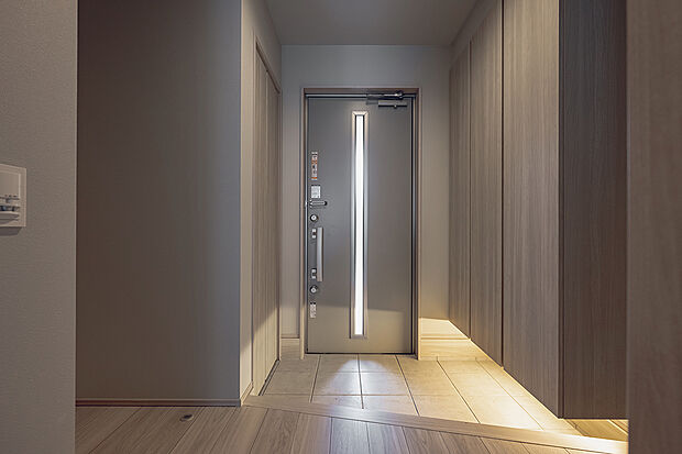 【玄関(1号棟)】家族やお客様を気持ちよく迎える、明るい玄関。間接照明がおしゃれな空間を演出しています。