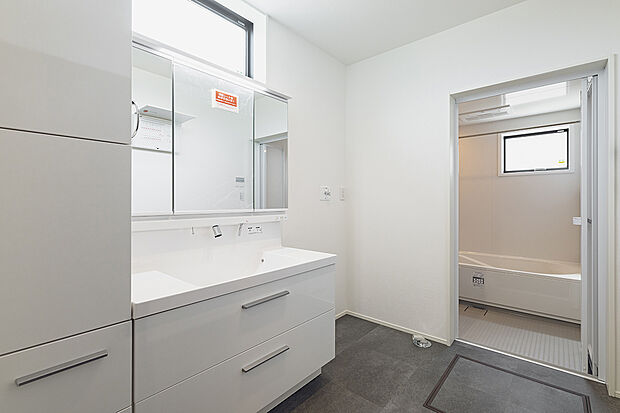【洗面室(2号棟)】白を基調とした爽やかな洗面室。大容量の収納を備えています。