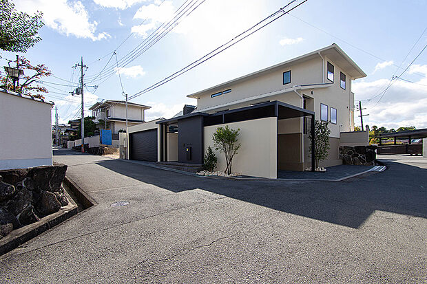 【ビルトインガレージがある住まい】B号地現地外観写真（2024年11月撮影）
B号地では屋根付きのシャッター付きビルトインガレージのある住まいを建築させて頂きました。前面道路幅は約5.5mを確保しているので車の出し入れもスムーズです。