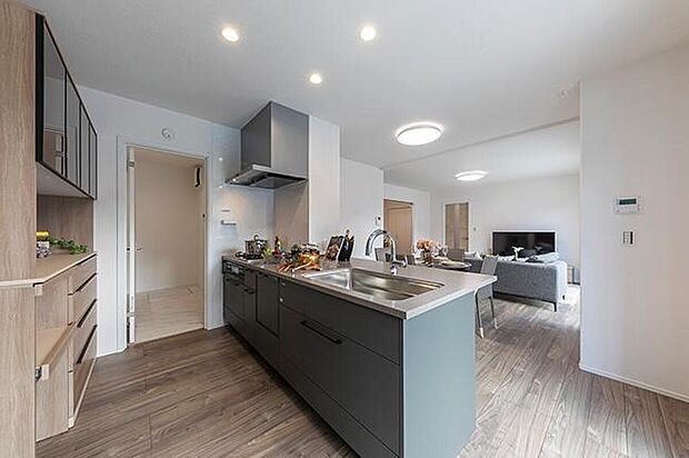 【【キッチン/No.6】】キッチンは緑系のくすみカラーを採用し、自然で落ち着いた印象を演出しています。奥の扉は洗面所に繋がっており、調理と洗濯など、家事の同時進行もスムーズです。