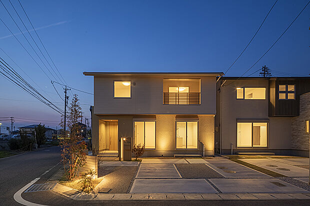 【【外観(夕景)/No.1】】玄関ポーチのライトは人感センサー付き。夜には人の接近を感知して自動で点灯します。庭木や外壁がライトアップされ、昼間とは違う表情を楽しむことができます。