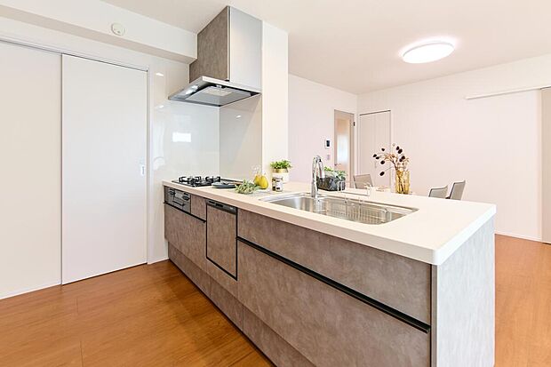 【【キッチン施工例】】調理中にリビングの様子が見守れる、対面式キッチン。家事負担軽減に役立つ、食器洗乾燥機を搭載。シンク下の収納はスライド式なので、奥にしまった鍋類などが取り出しやすい仕様です。