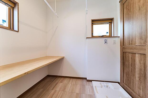 【【ランドリールーム/98号棟】】洗面台と脱衣スペースを分離し、脱衣スペースはランドリールームとしても使えるように室内物干しを設置。カウンターがあるので、洗濯からアイロンがけまで一ヶ所で完結できます。