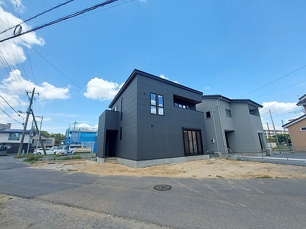 【外観写真（道路有）】南西５ｍ公道に面する、日当たりの良い立地にある箱型デザイン。
ガルバリウムの屋根とインナーバルコニーを採用した箱型の造形と濃配色の外壁の組み合わせが生えるモダンな佇まいです。