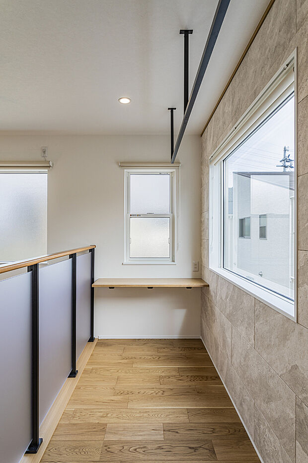 【【物干しスペース/当社施工例】】リビングと吹抜けで繋がった2階の空間。壁一面に調湿機能のあるタイルを施すことで、湿気が気になりにくい仕様です。洗濯物が気持ちよく乾き、バルコニーのお手入れの手間が省けます。