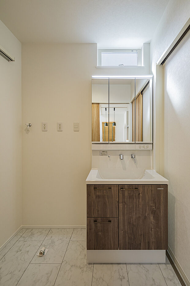 【【7号地モデルハウス/洗面室】】木目調の洗面化粧台は、家具のようなお洒落な雰囲気。洗面ボウル下の収納スペースに化粧品やタオルなどをすっきりと収納可能です。窓があり、自然光を採り込めます。