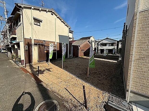 【現地建築前写真】周辺は住宅が立ち並ぶエリア。前面道路と高低差がほぼなく、お車や2輪車の出し入れがスムーズです。中央環状線や東大阪JCTもアクセスしやすい立地で、お車での広域移動も便利です。