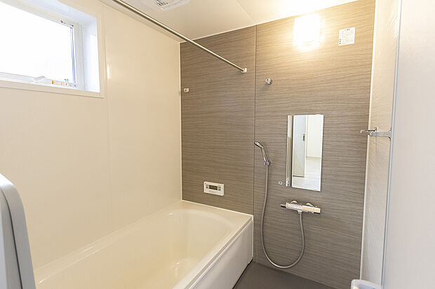 【【1階バスルーム/A号地モデルハウス】】足を延ばしてリラックスできるバスルームは、木目調のアクセントパネルが落ち着いた印象。カウンターレスのためお掃除がしやすく、洗い場を広く使うことができます。