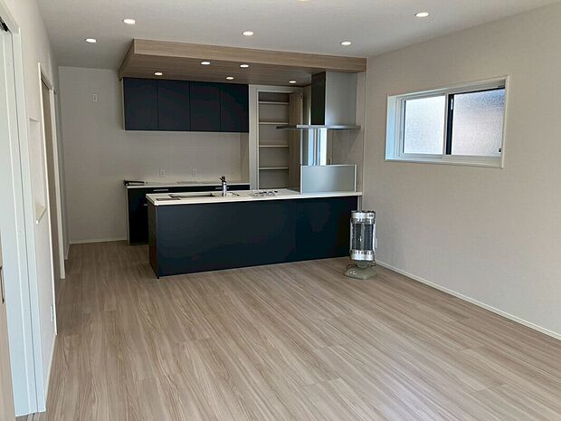 【7号地内観（LDK）】飽きの来ない優しい床材とメリハリの付いたネイビーカラーのキッチンが2026年のトレンドを抑えた内観となっております。