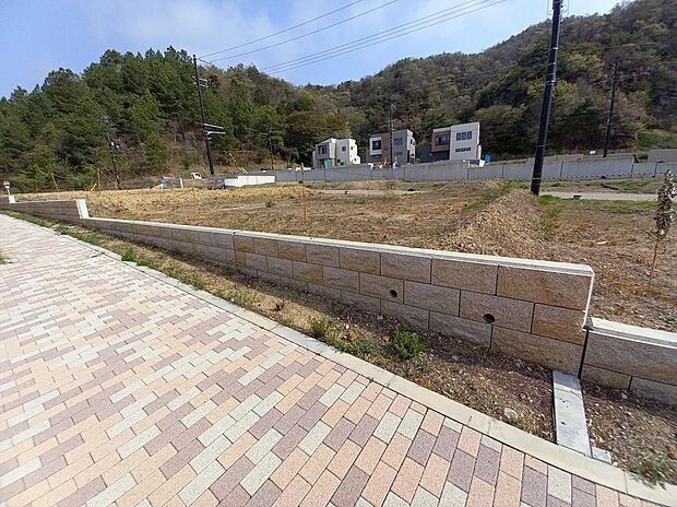 美しい石貼りの擁壁やカラーアスファルトが彩る街並みが魅力的な分譲地。2方向開放で陽当たりや風通しが良く、眺望も抜群です。緑豊かな環境で、子どもも安心して歩ける街並みです。