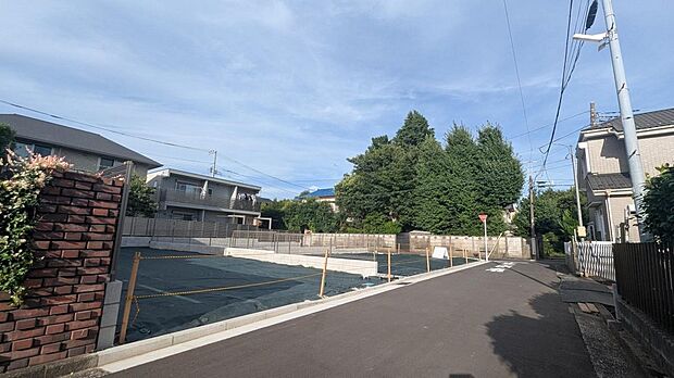 現地前面道路から望む、緑豊かで落ち着いた街並み。低層住宅が並び、空の広がりを感じられる住環境です。