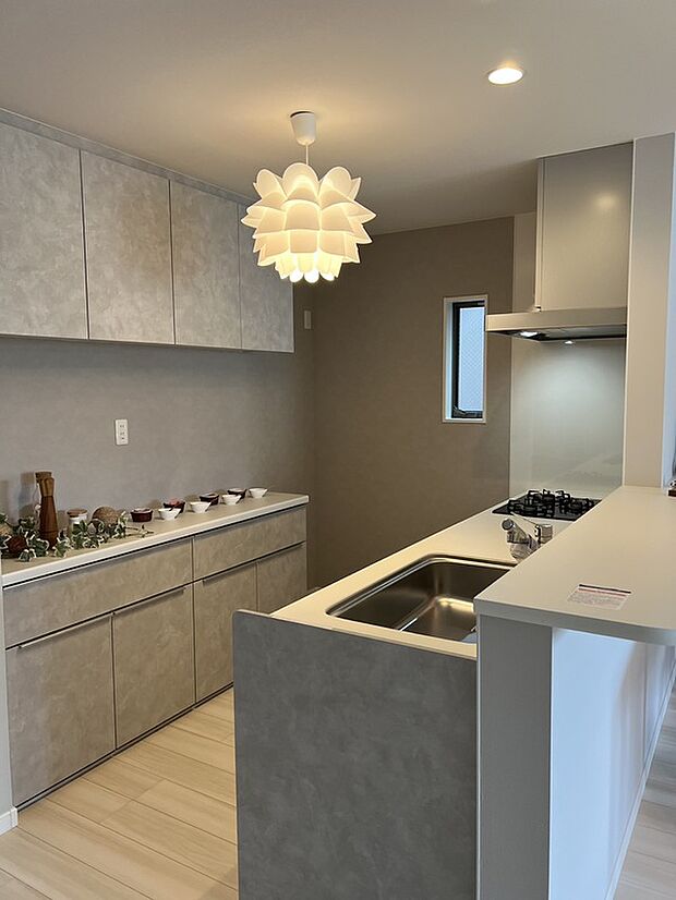 【【プラン例】】壁面にはキッチンカラーに合わせた吊戸棚とカップボードを設置しています。