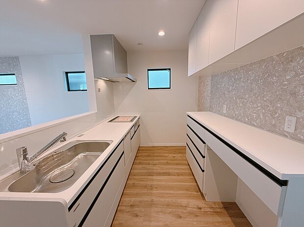 【【施工例】キッチン】対面キッチンに吊戸棚やカップボードを備え、最新システムキッチンで家事効率が向上!家族との会話も楽しめる設計です。