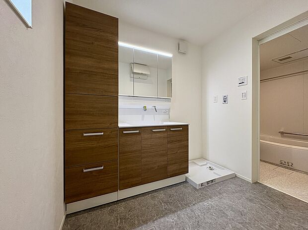 【洗面室/1号棟】身支度の際に便利な三面鏡タイプの洗面台です。鏡横や洗面ボウル下、鏡裏にも収納スペースが備わっており、洗面用品やタオル類などをたっぷり収納できます。