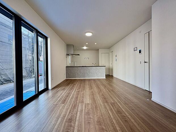 【【LDK/2号棟】】ナチュラルな色合いのフローリングと白いクロスのLDK。お好みのインテリアを自由に楽しめそうです。ご家族との会話が弾む、対面式キッチンが採用されています。