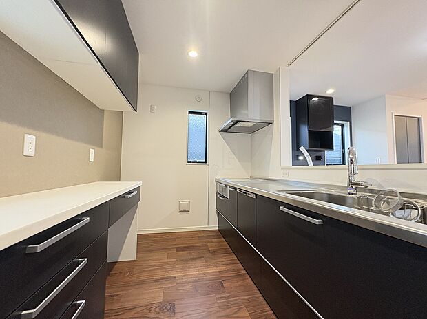 【【キッチン】】広々とした対面式キッチン。リビングで過ごすご家族とコミュニケーションを楽しみながら作業可能です。背面には造作キャビネットが備わっており、調理家電などを並べることができます。