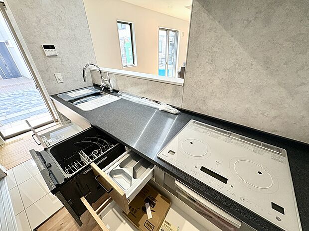 【【A号棟キッチン】】IHクッキングヒーターや食洗機が搭載された、使い勝手良好なシステムキッチンです。対面式で、作業中もリビングで過ごすご家族と会話を楽しみながら作業可能です。