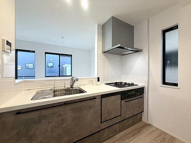 【【キッチン】】リビングを見渡せる対面キッチンは、お子様の様子を見守りながら安心して家事がこなせます。ダウンライトの柔らかな光が演出する明るい空間で、毎日の料理タイムを幸せな時間に。