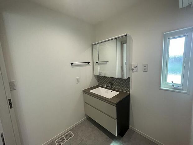 【B号地洗面脱衣室】おしゃれなタイルが目を引く三面鏡付洗面台。(202409撮影)