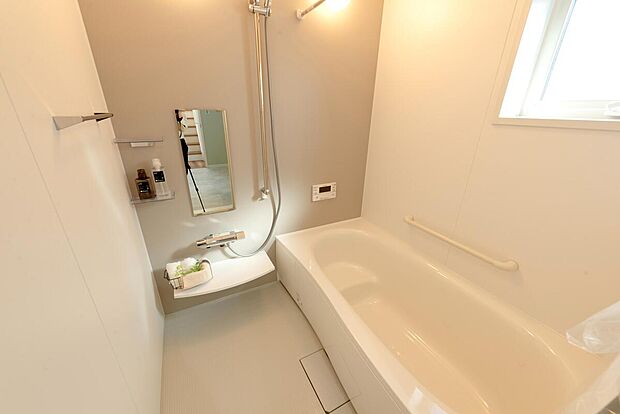 【【1階浴室/B号地モデルハウス】】浴槽は半身浴がしやすく、節水効果が期待できるベンチ型！立ち座りをサポートする手すり付きです。キッチンからランドリールーム、浴室などの水回りがすぐで、お子様の入浴のお世話がしやすい配置です。