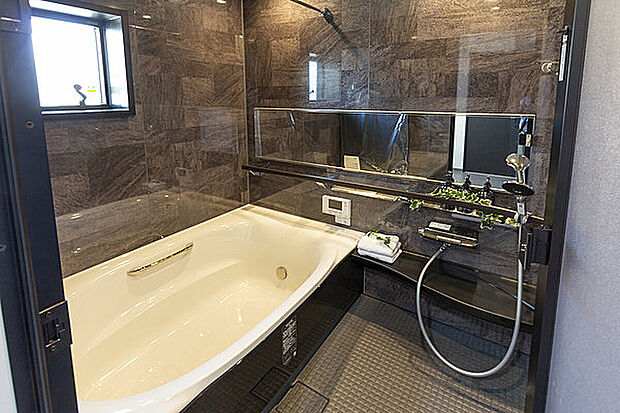 【【当社施工例】】光沢のあるアクセントパネルを施した、高級感のある浴室。落ち着きのある空間で、ゆったりと湯船につかり、一日の疲れを癒していただけそうです。お子様との入浴も快適な、ゆとりある広さを確保しています。